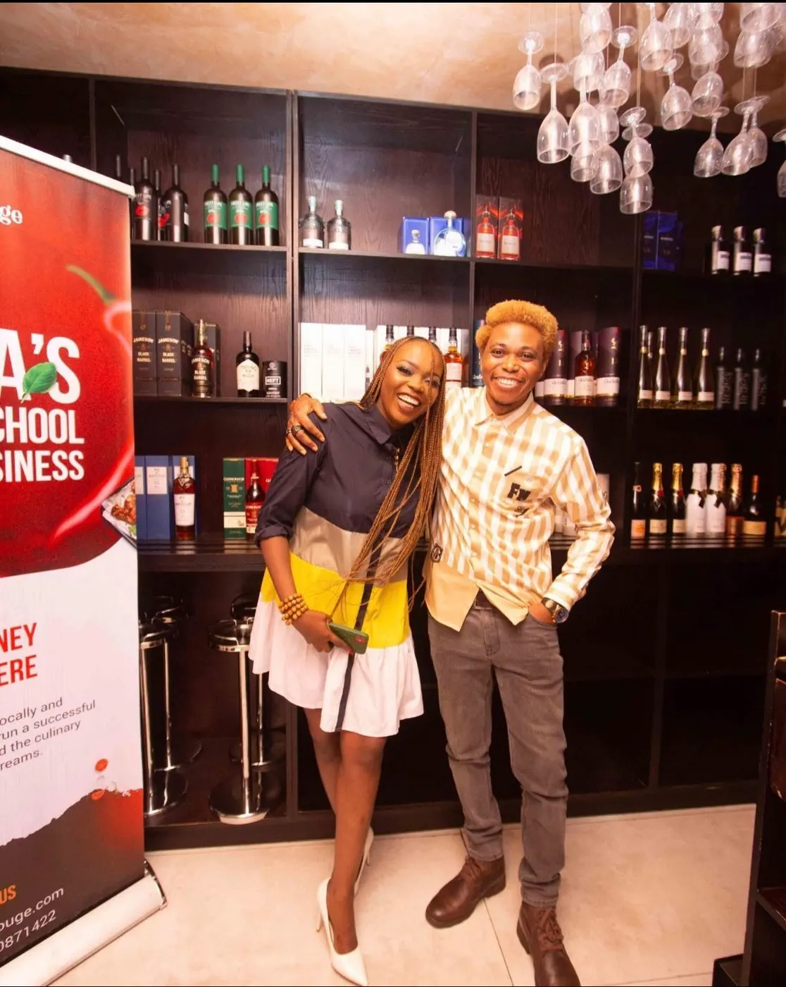 Two people posing at the bar beside an Almond Rouge banner