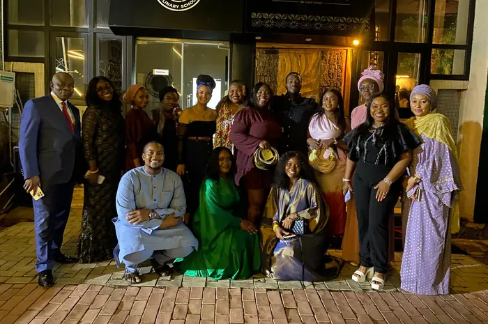 A large group gathered outside the culinary school entrance in the evening