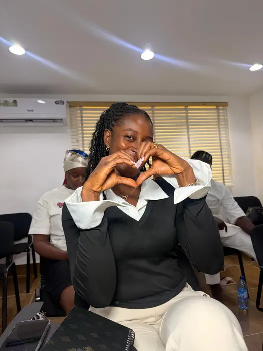 A student making a heart shape with her hands during a classroom session